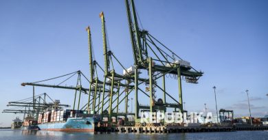 Kapal nelayan melintas dengan latar belakang aktivitas bongkar muat peti kemas di New Priok Container Terminal One, Jakarta, Selasa (1/7/2025).