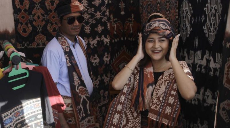 Pengunjung mencoba tenun ikat dari Kabupaten Sumba Timur di salah satu stan Pelaku Usaha Mikro Kecil dan Menengah (UMKM) pada Koepan Expo 2022 yang digelar di Kota Kupang, NTT, Selasa (21/6/2022). Koepan Expo yang berlangsung hingga Rabu (23/6/2022) itu melibatkan 30 pelaku UMKM yang menjual produk-produk NTT seperti tenun ikat dan makanan khas NTT sebagai bagian dari pemulihan ekonomi di NTT.