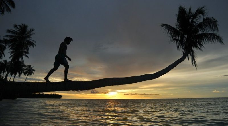 Pengunjung menikmati matahari terbenam di Pantai Mapadegat, Mentawai, Sumatra Barat.