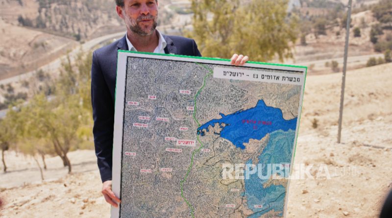 Menteri Keuangan Israel Bezalel Smotrich memegang peta yang menunjukkan proyek pemukiman E1 saat konferensi pers di dekat pemukiman Maale Adumim, di Tepi Barat yang diduduki Israel, Kamis, 14 Agustus 2025.