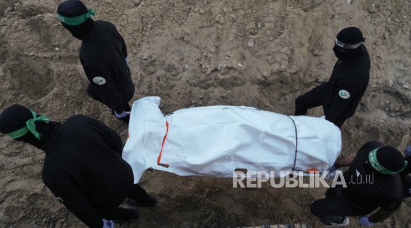 Militan Hamas membawa tas putih yang diyakini berisi jenazah sandera, setelah mengambilnya dari terowongan saat pencarian sisa-sisa sandera di Kota Hamad, Khan Younis, di Gaza selatan, Selasa, 28 Oktober 2025.