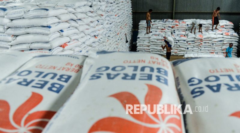 Pekerja memanggul karung berisi beras di gudang Perum Bulog Umbul Tengah, Kota Serang, Banten.