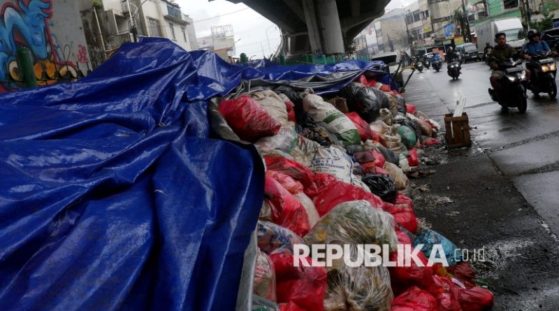 Pengendara motor melintas di samping tumpukan sampah yang ditutupi terpal di Ciputat, Tangerang Selatan, Banten, Selasa (16/12/2025). Pemerintah Kota Tangerang Selatan menutup tumpukan sampah menggunakan terpal sebagai bentuk penanganan sementara untuk mengurangi dampak bau selama masa penataan Tempat Pembuangan Akhir (TPA) Cipeucang yang membuat aktivitas pengangkutan sampah dihentikan sementara.