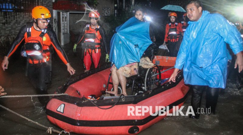 Petugas Basarnas Manado menggunakan perahu karet mengevakuasi lansia yang terjebak banjir di Karame, Manado, Sulawesi Utara, Sabtu (22/3/2025).