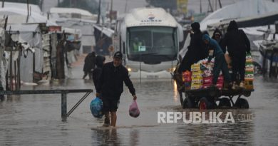 Warga Palestina berjalan melalui jalan yang banjir setelah hujan lebat di Khan Younis, Jalur Gaza selatan, Kamis, 11 Desember 2025.