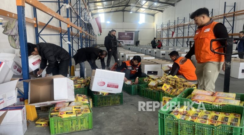 Para relawan tengah memasukkan bahan makanan ke dalam dus paket bantuan untuk pengungsi Palestina